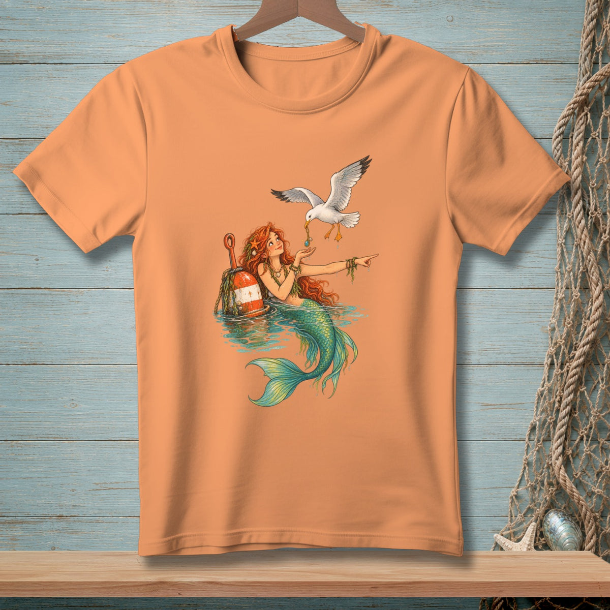 Mermaid with red hair and green tail feeding a seagull near a buoy.