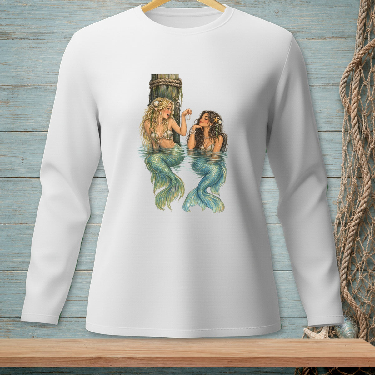 Two mermaids with blonde and brown hair sit in water by a wooden post.