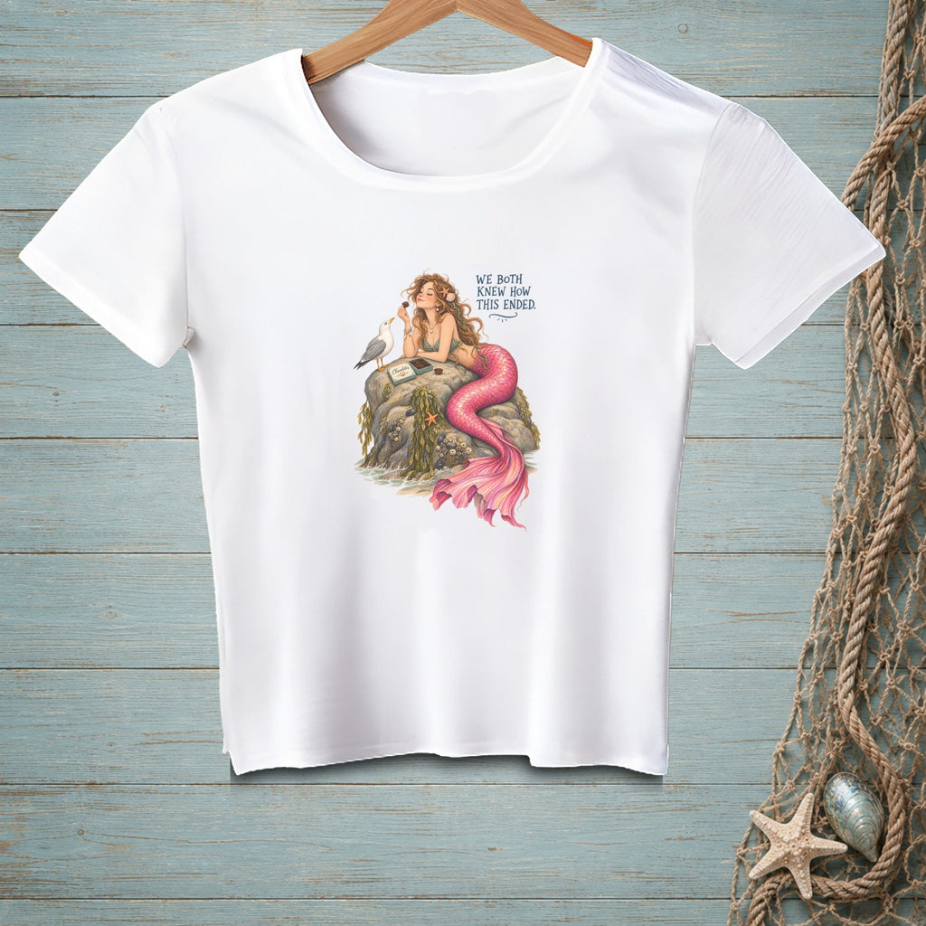 Mermaid on rock with a seagull and chocolate, text reads "We Both Knew How This Ended".