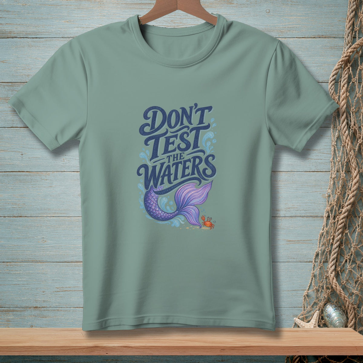Teal t-shirt with "Don't Test the Waters" text, mermaid tail, and crab.
