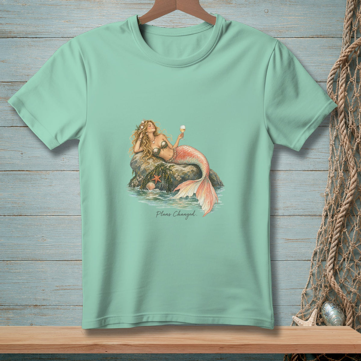 Mint green t-shirt with a mermaid lounging on a rock, holding an ice cream, and text "Plans Changed."