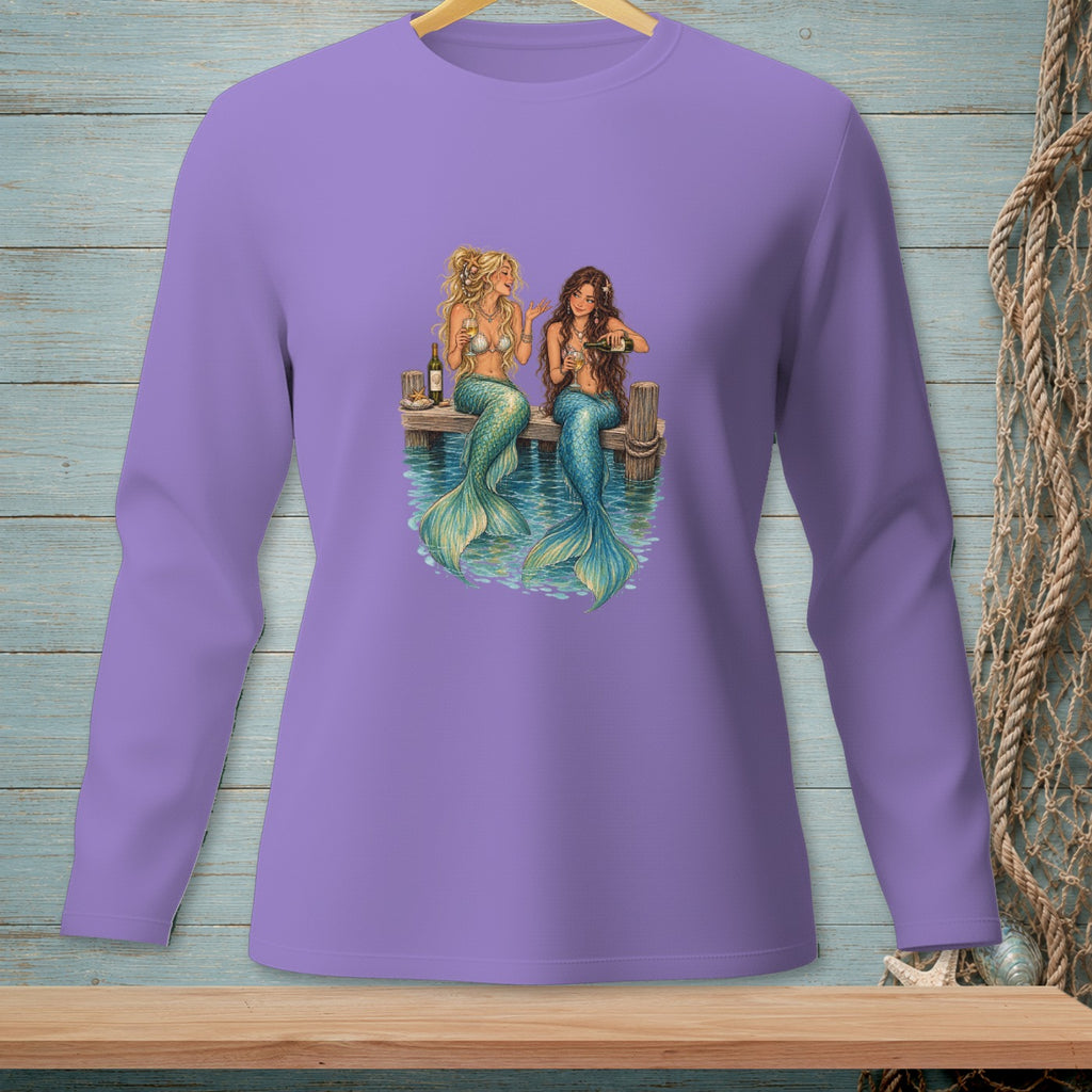 Two mermaids sitting on a dock, drinking champagne.