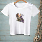White t-shirt with mermaid on rock, holding a martini glass, with text.