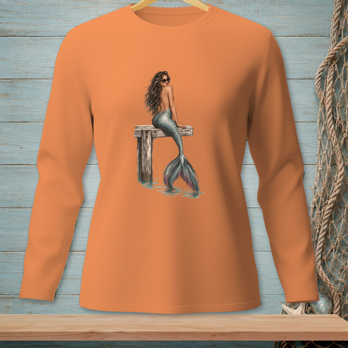 Orange long-sleeve shirt with a mermaid on a dock and the text "YOU AGAIN?".