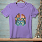 Two mermaids sit on a dock talking, with tails in the water.