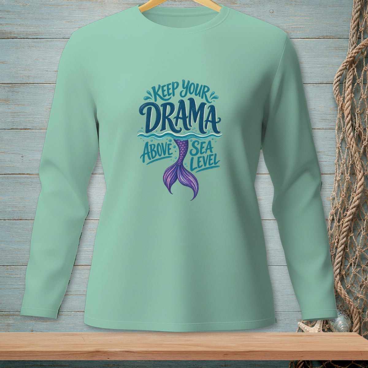Mint long-sleeve shirt with "Keep Your Drama Above Sea Level" and mermaid tail graphic.