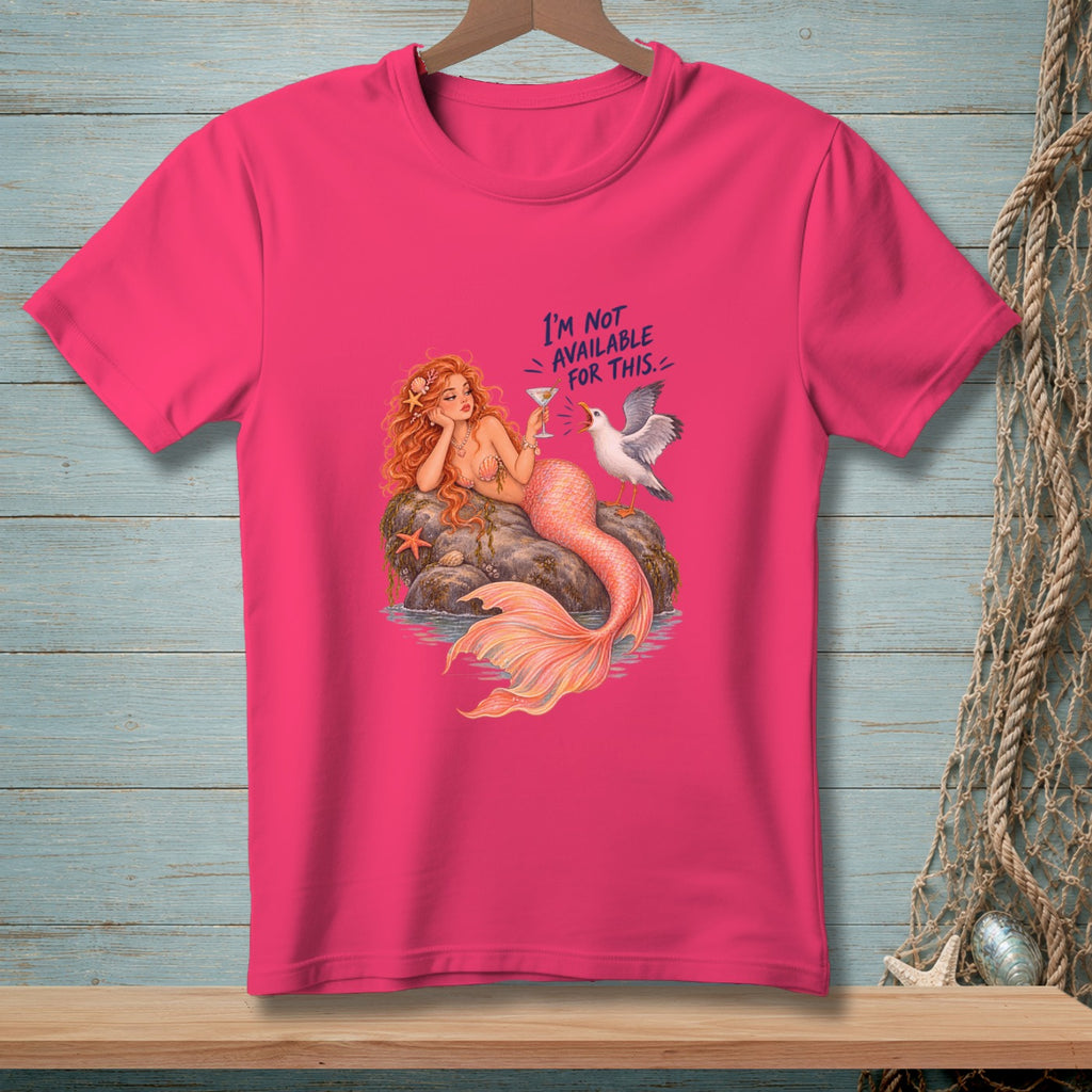 Pink t-shirt with a mermaid holding a drink and a seagull saying "I'm not available for this."