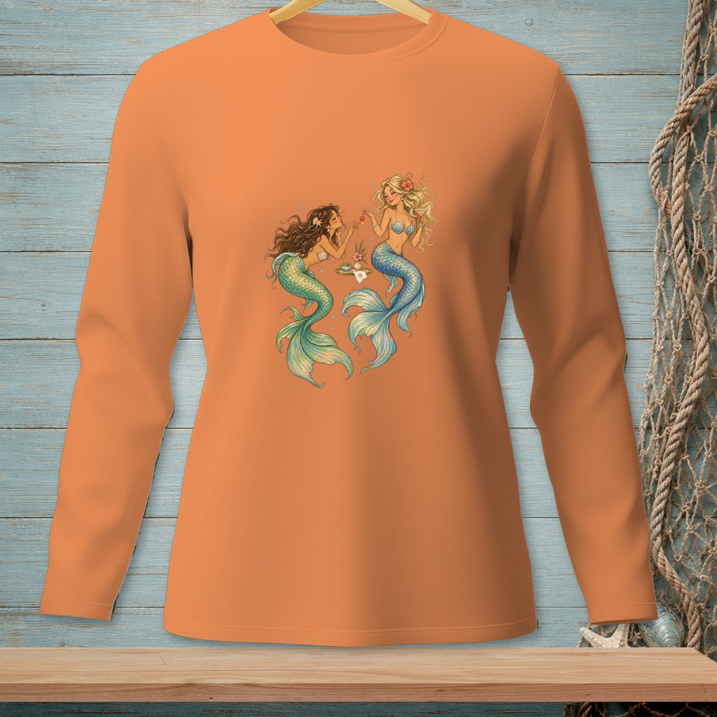 Orange long-sleeve shirt with a print of two mermaids sharing drinks.