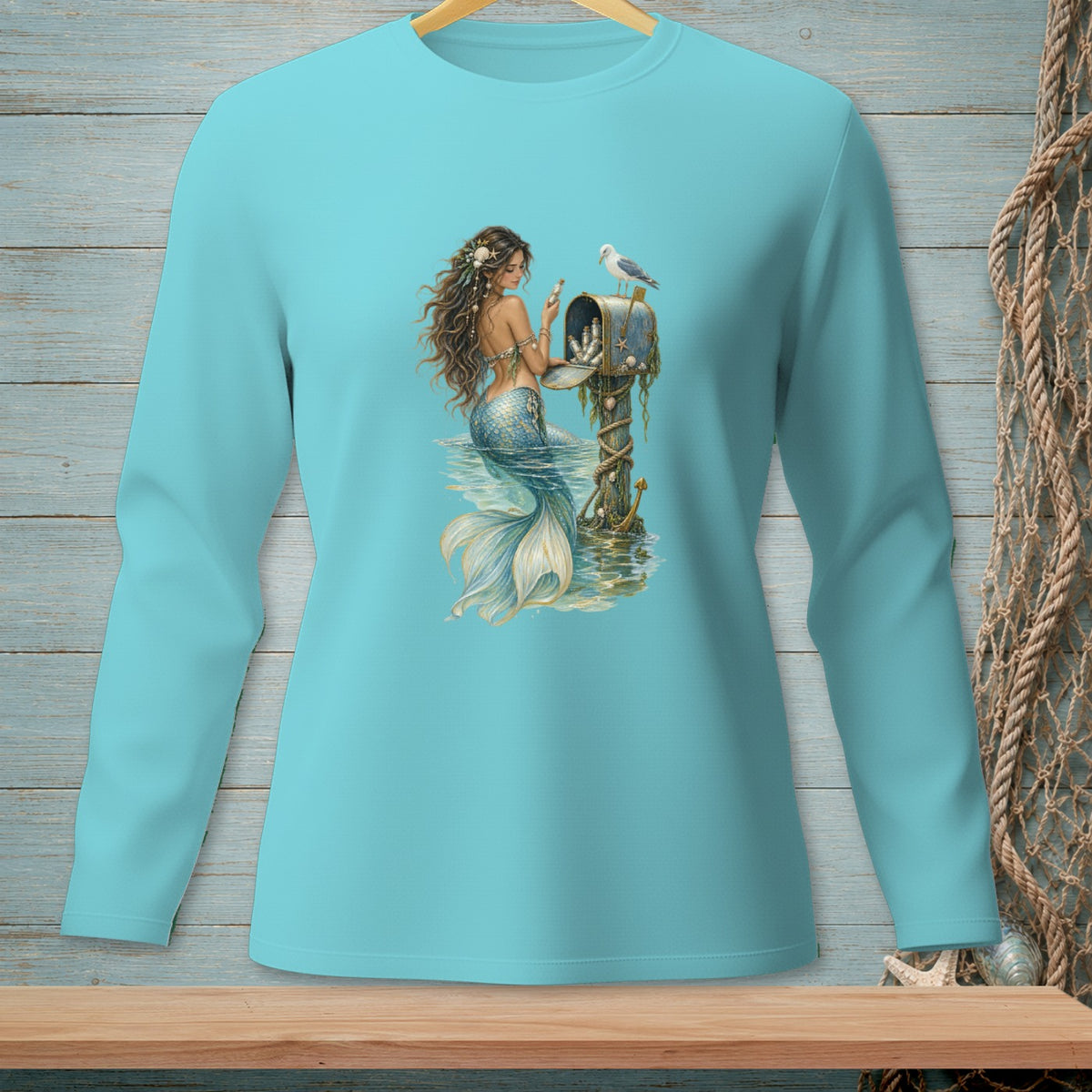 Mermaid at a mailbox with a seagull on a blue long-sleeve shirt.