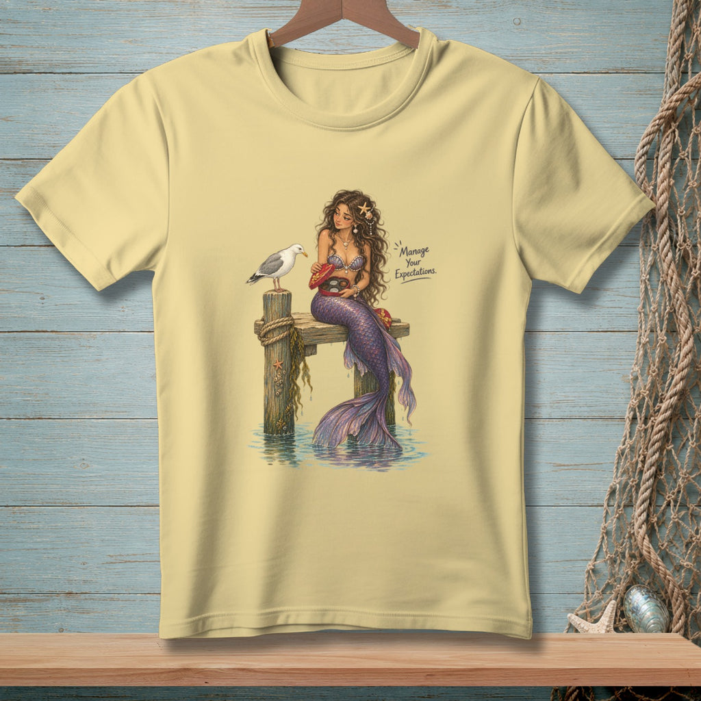 Mermaid on dock offering chocolates to seagull, with text "Manage Your Expectations."