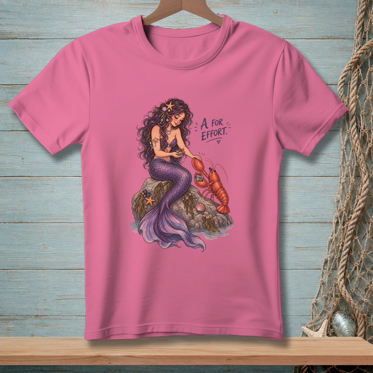 Mermaid with lobster and text "A for Effort" on pink t-shirt.