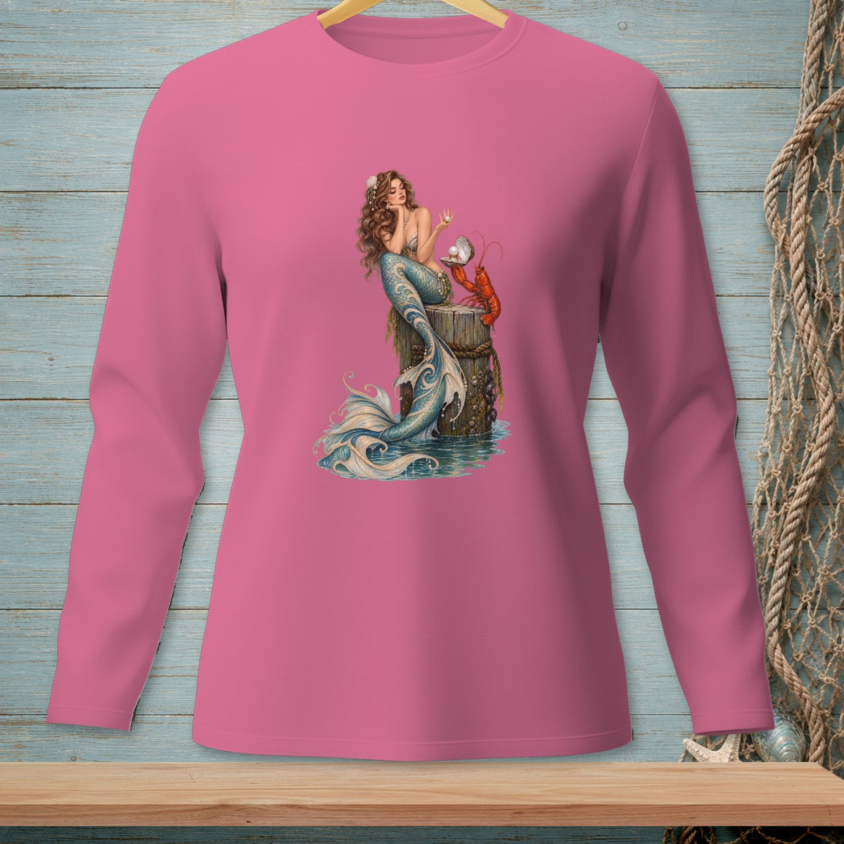 Pink long-sleeve shirt with a mermaid and lobster design on a post.