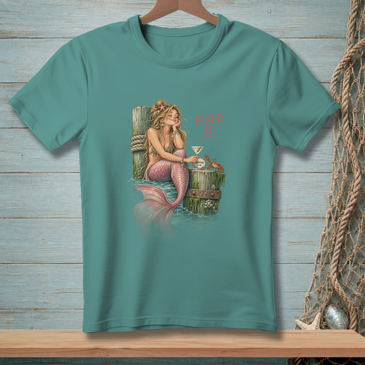 Mermaid with pink tail and martini glass on a pier, "Fixed It" text.
