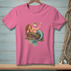 Pink t-shirt with illustration of a mermaid holding a drink next to a pufferfish.