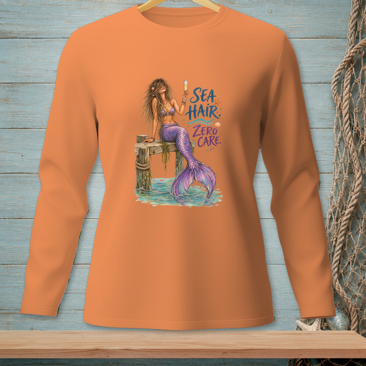 Orange long sleeve shirt with a mermaid graphic and the text "SEA HAIR: ZERO CARE."