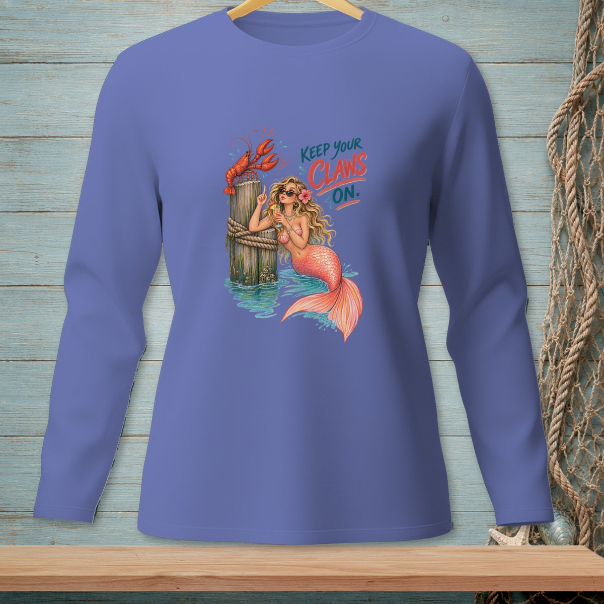 Mermaid with lobster and text "KEEP YOUR CLAWS ON." on purple shirt.