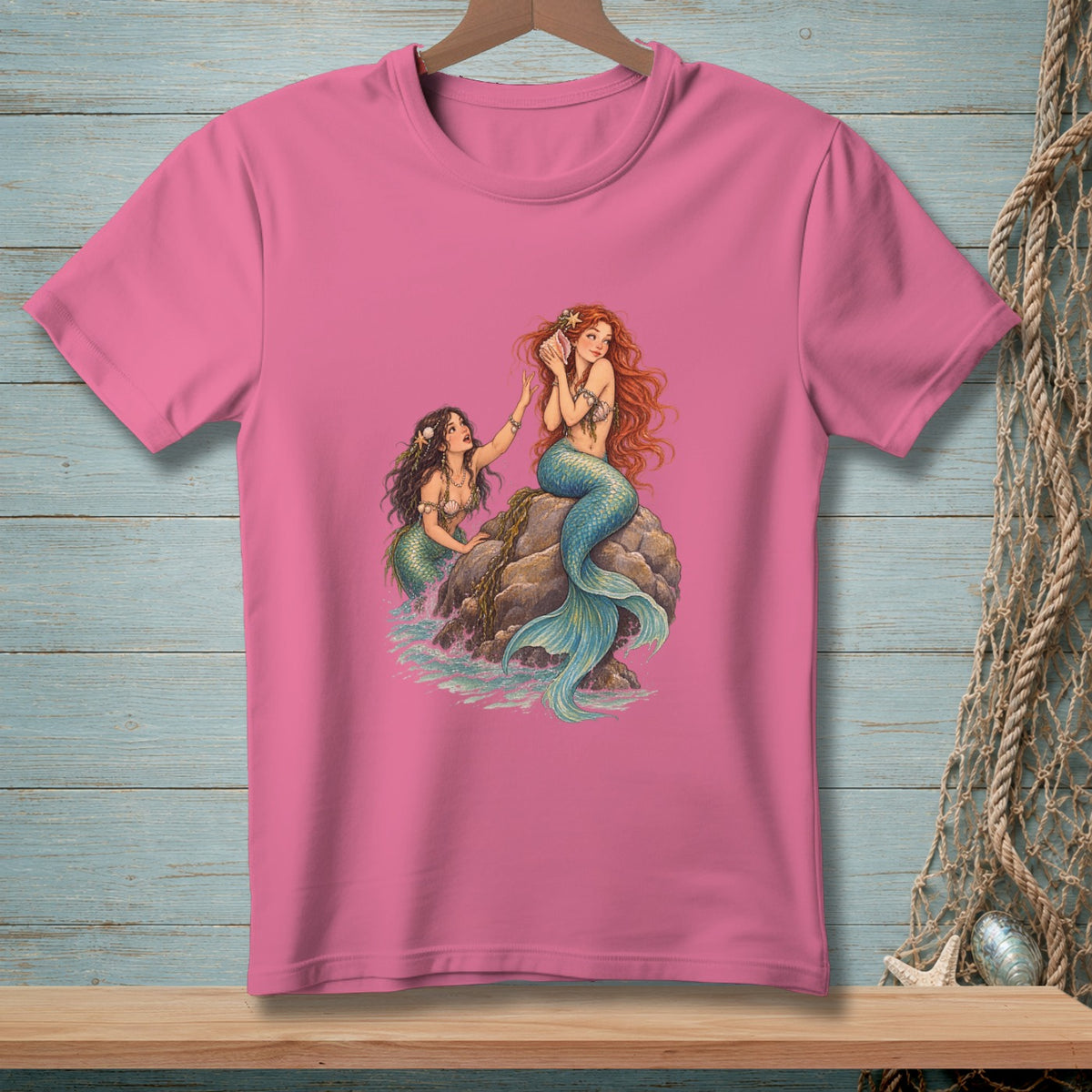 Two mermaids on a rock by the sea, one holding a seashell.