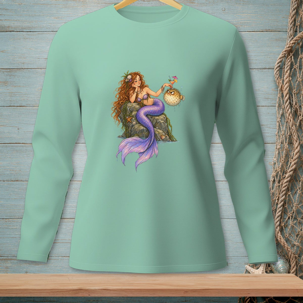 Mermaid with purple tail offers a drink to a grumpy pufferfish on a rock.