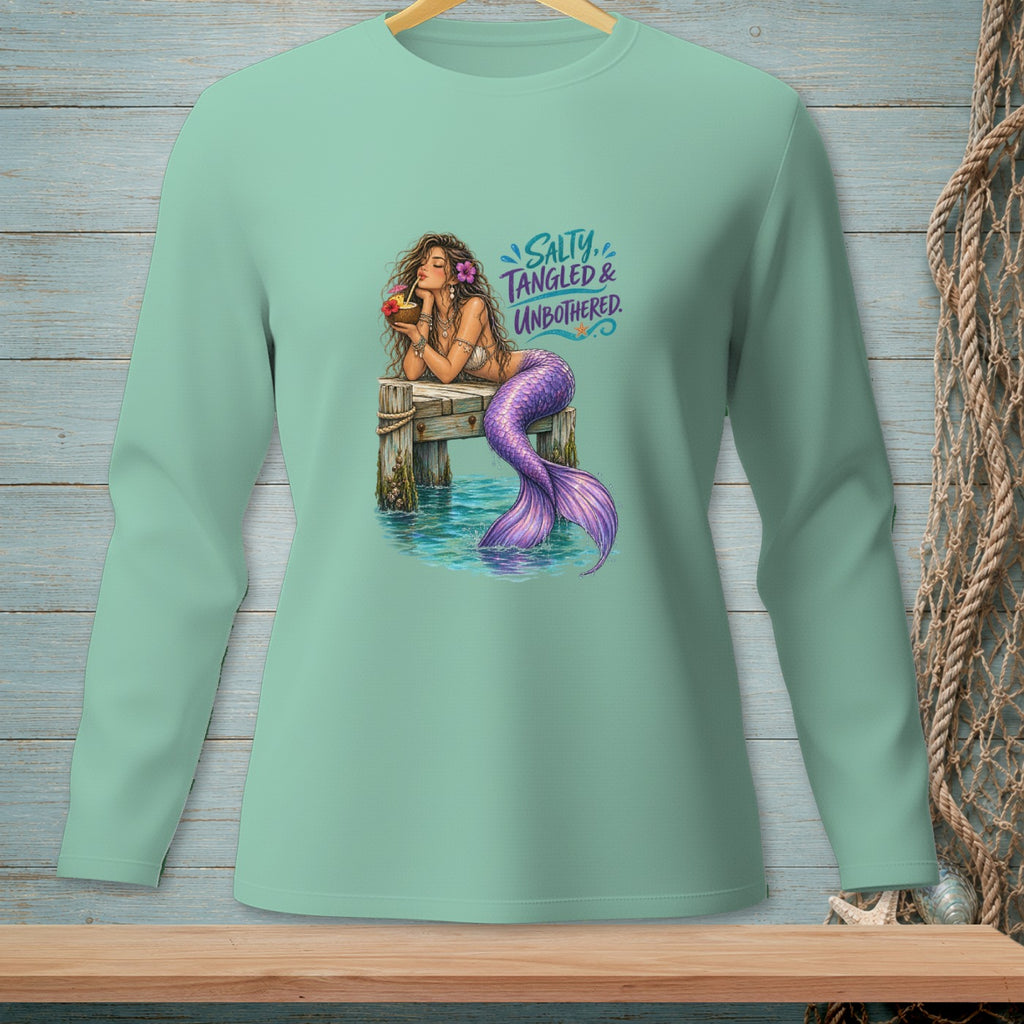 Mermaid with purple tail drinks from coconut on pier with text "Salty, Tangled & Unbothered."