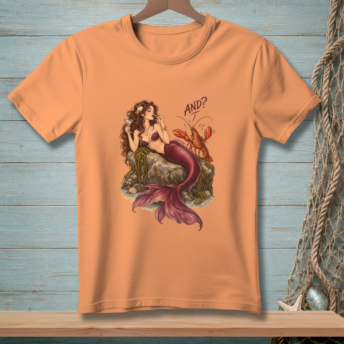 Orange t-shirt with mermaid and lobster graphic that says "AND?"