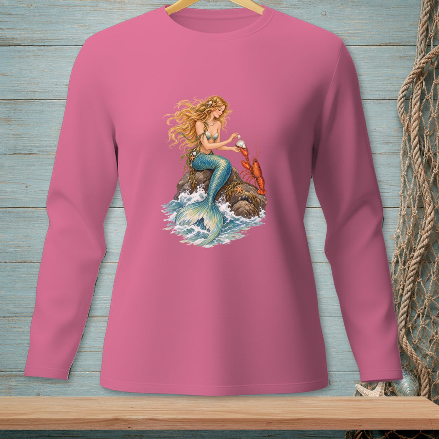 Pink long-sleeve shirt with a mermaid and lobster graphic on a rock in the ocean.