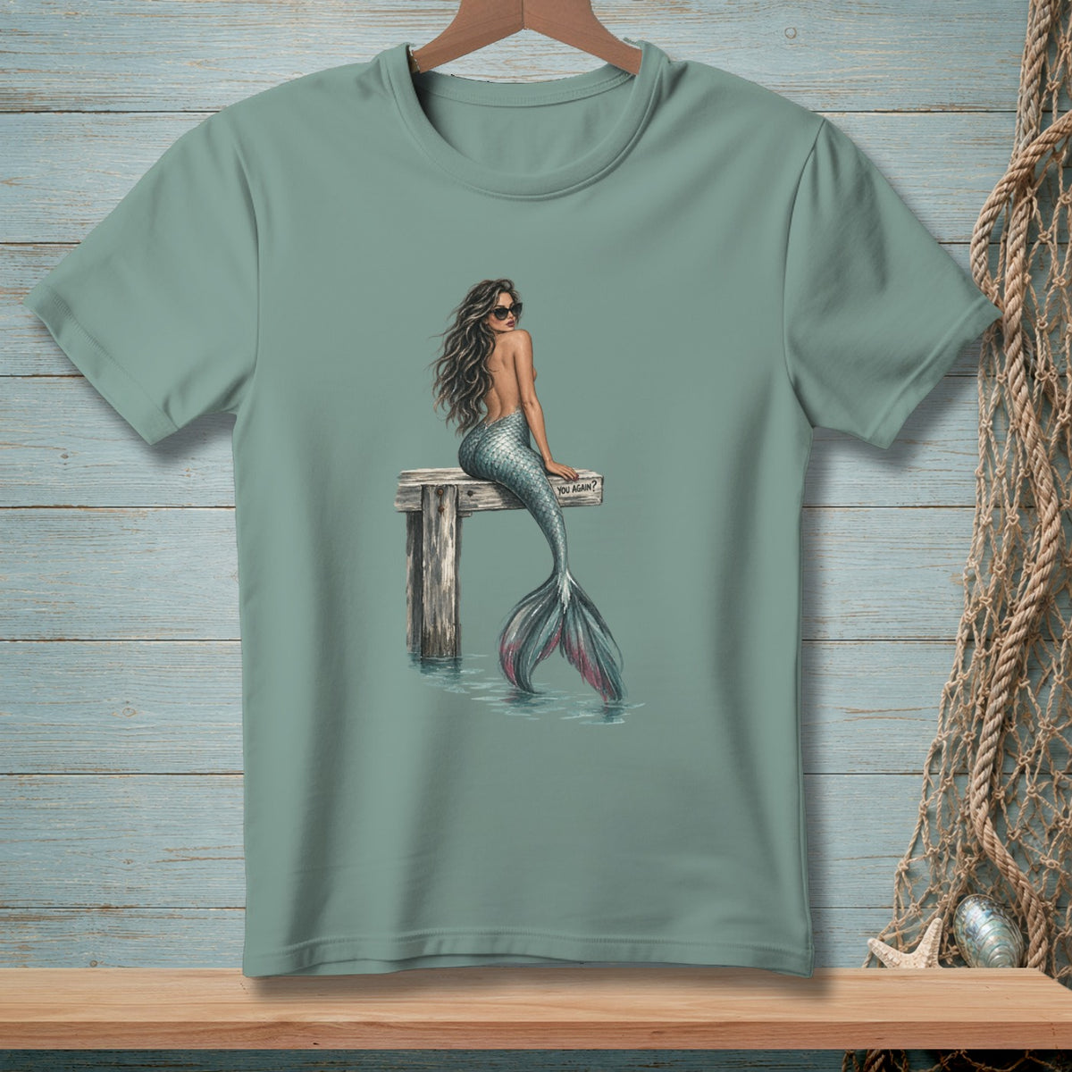 T-shirt with a mermaid in sunglasses sitting on a dock, text reads "YOU AGAIN?"