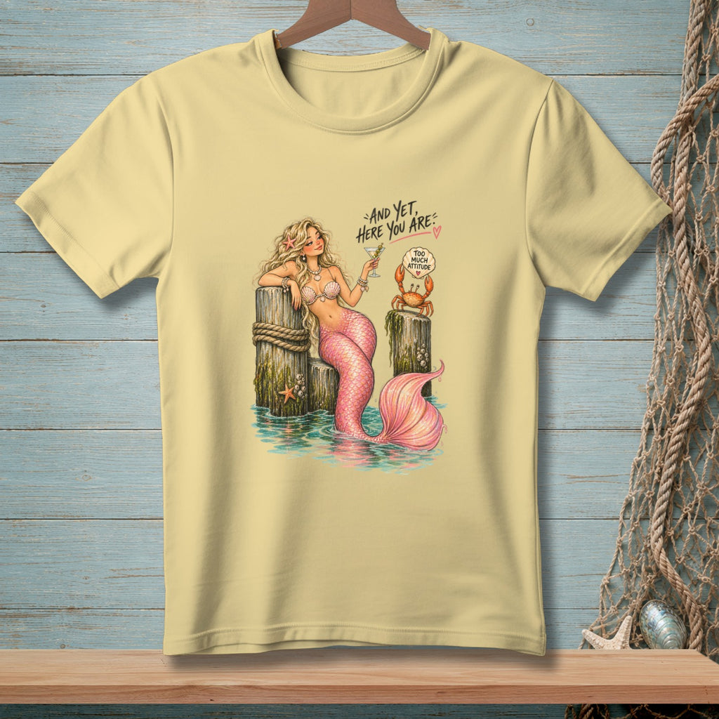 Yellow t-shirt with a mermaid, crab, and text "And yet, here you are".