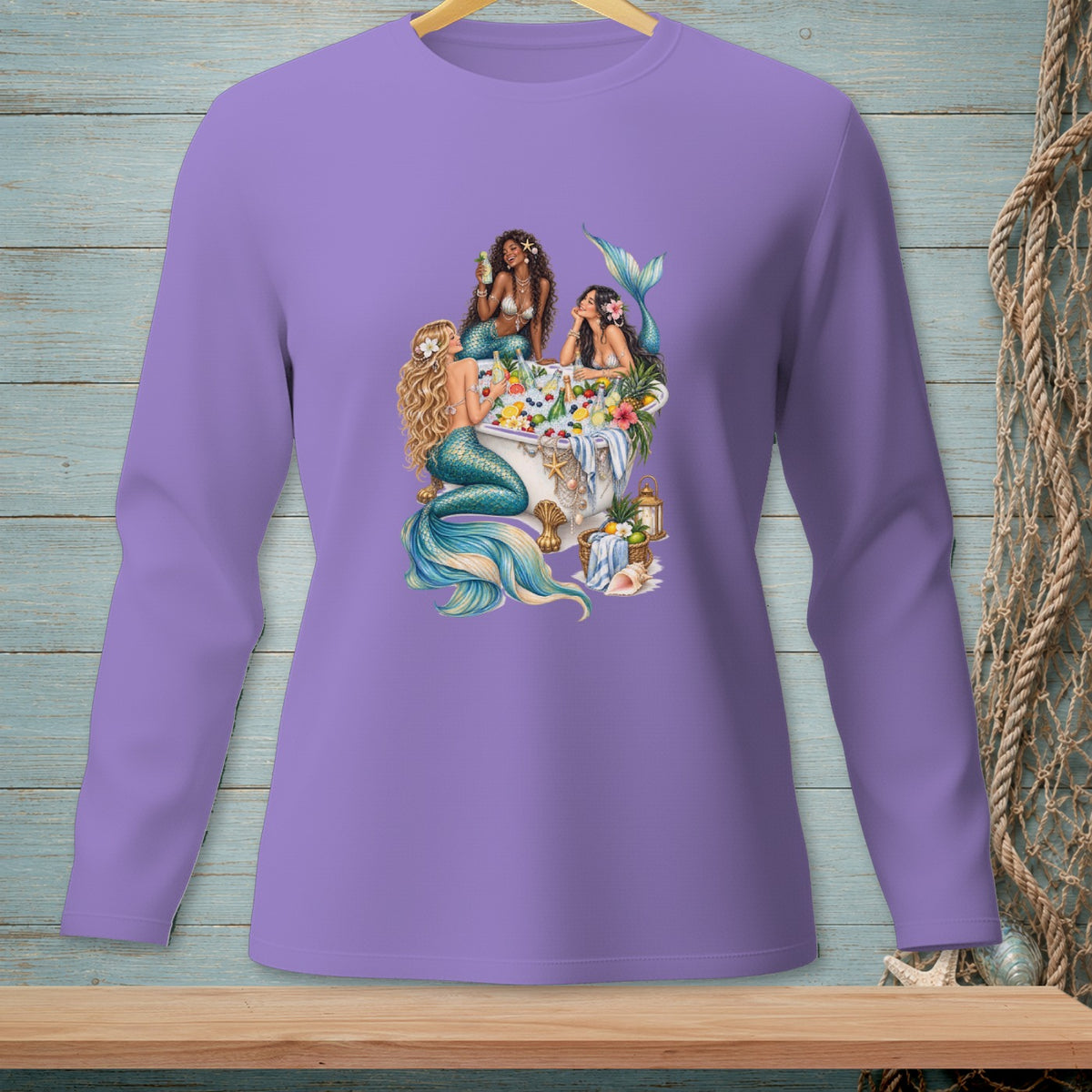 Three mermaids in a tub filled with fruit and flowers, on a purple long-sleeve shirt.