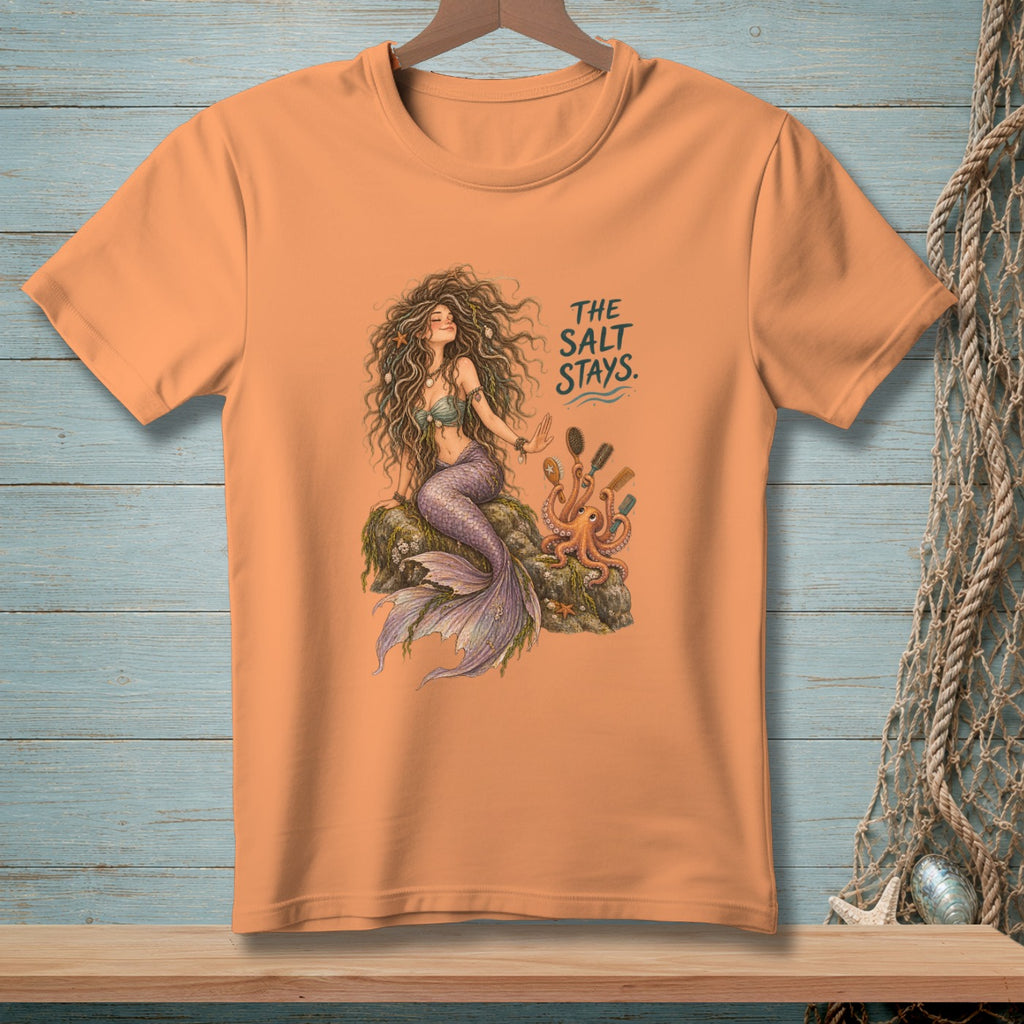 Orange t-shirt with a mermaid and octopus illustration, text reads "THE SALT STAYS."