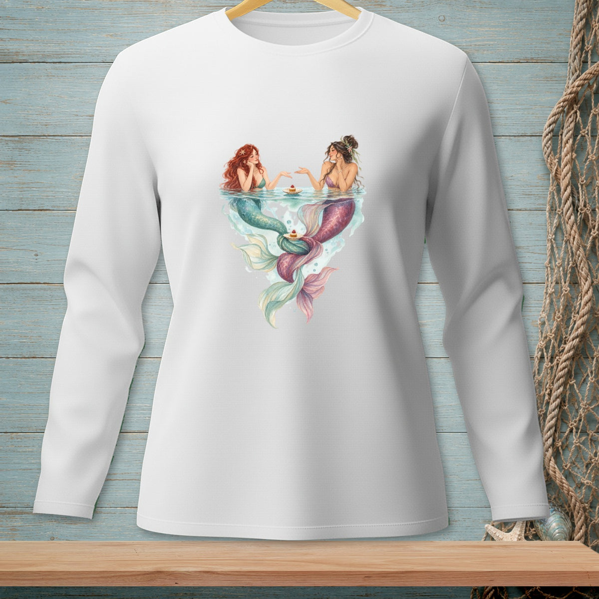 Two mermaids sharing cupcakes in water with colorful tails.