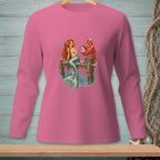 Pink long-sleeve shirt with a mermaid and lobster illustration on a dock.