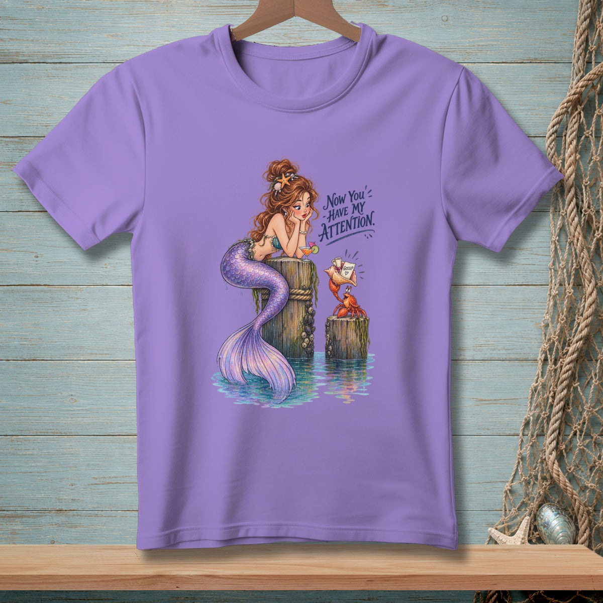 Mermaid and crab on pilings with text "Now You' Have My Attention".