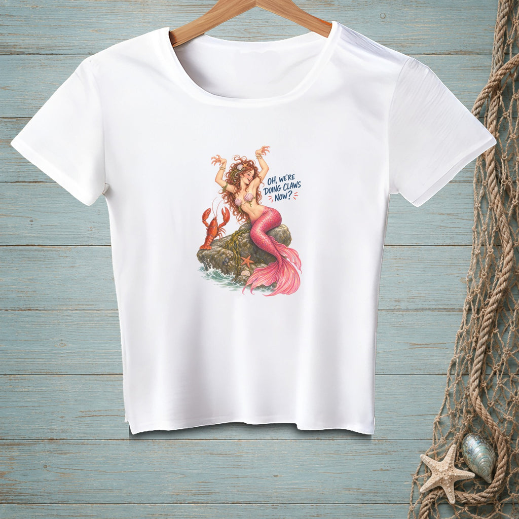 White t-shirt with a mermaid and lobster graphic that reads "Oh, we're doing claws now?".