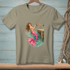 T-shirt graphic of a mermaid fishing from a dock with a hand holding a fishing rod.