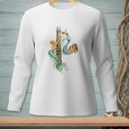 White long sleeve shirt with graphic of two mermaids reaching for a basket on a pier.