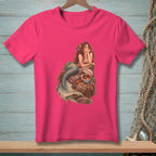 Pink t-shirt with mermaid art featuring a mermaid on rocks surrounded by shells and starfish.