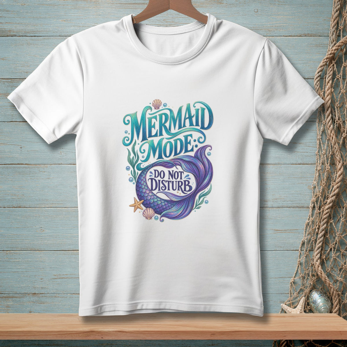 White t-shirt with "Mermaid Mode Do Not Disturb" text and mermaid tail design.