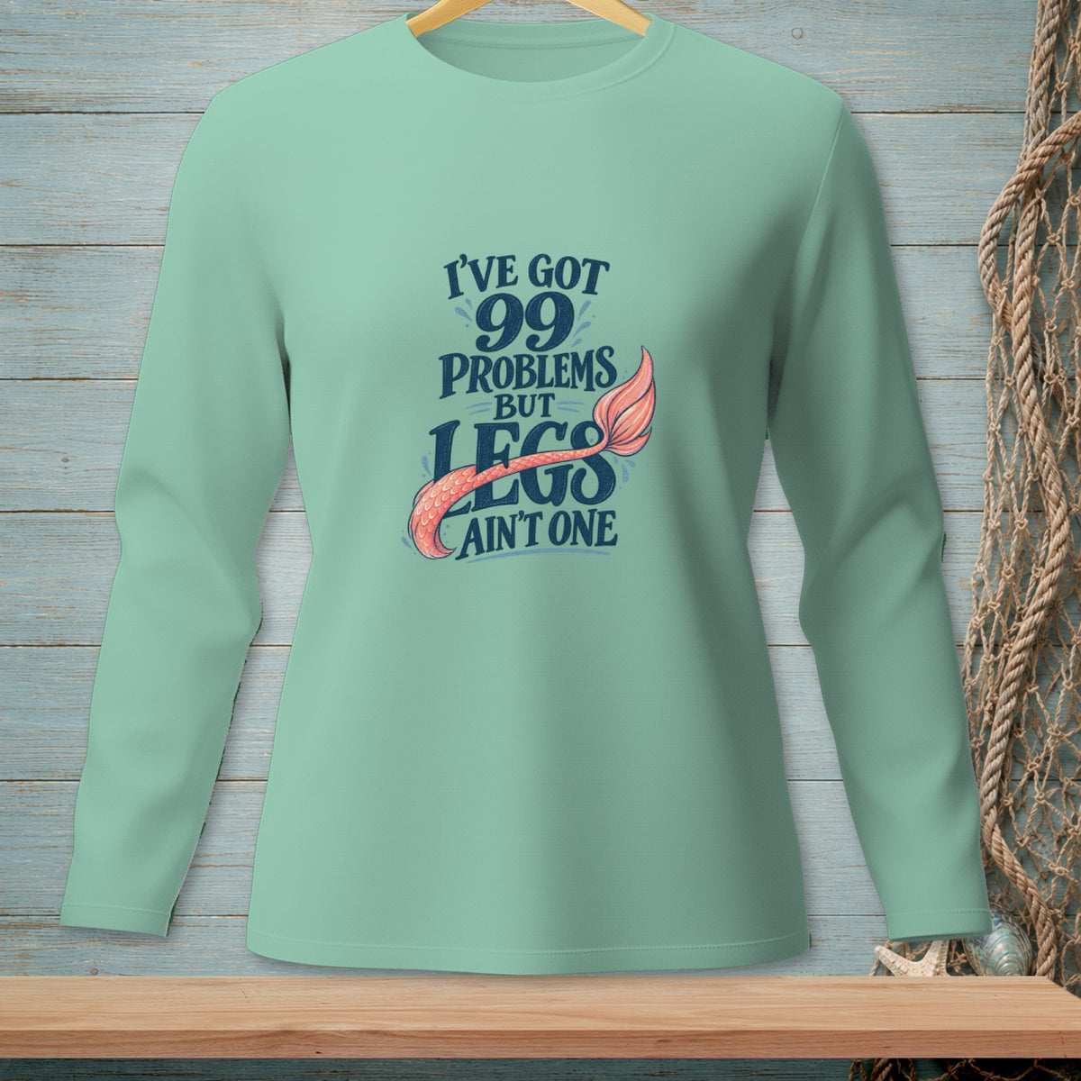Mint green long sleeve shirt with "I've got 99 problems but legs ain't one" text and mermaid tail.