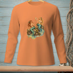 Orange long-sleeve shirt featuring two mermaids sitting on rocks with a seashell.