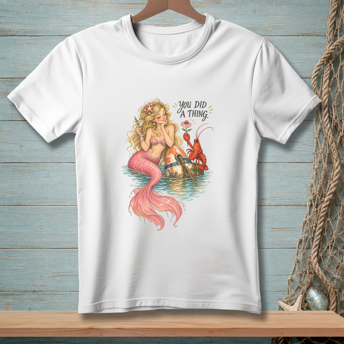Mermaid with lobster and text "you DID A THING" on white t-shirt.