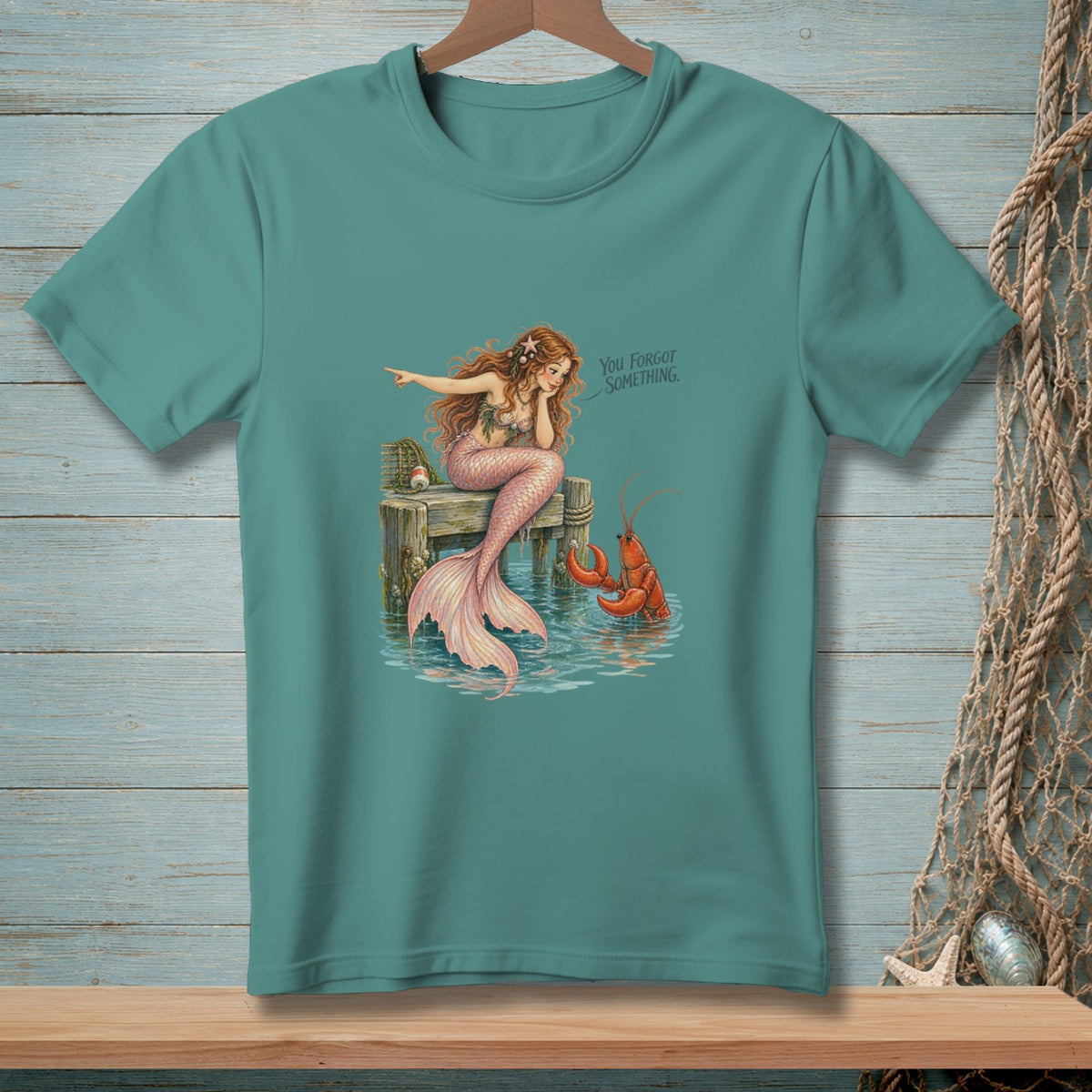 Mermaid on a pier points to a lobster in the water, with text "You Forgot Something."