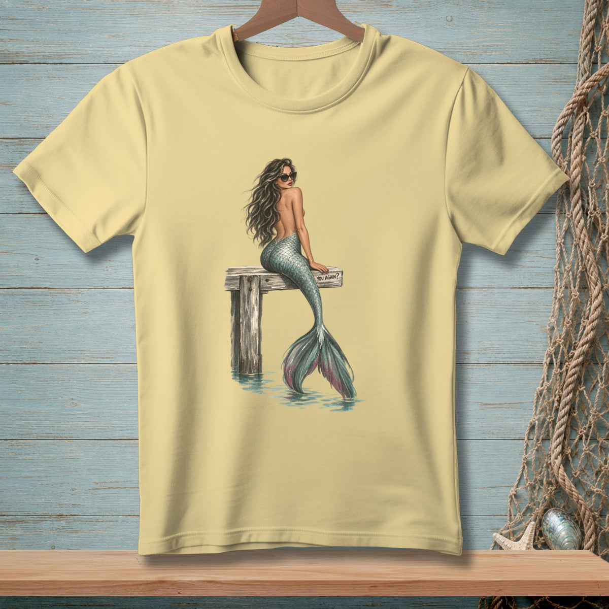 Yellow t-shirt with a mermaid on a pier, sunglasses, and the text "YOU AGAIN?".