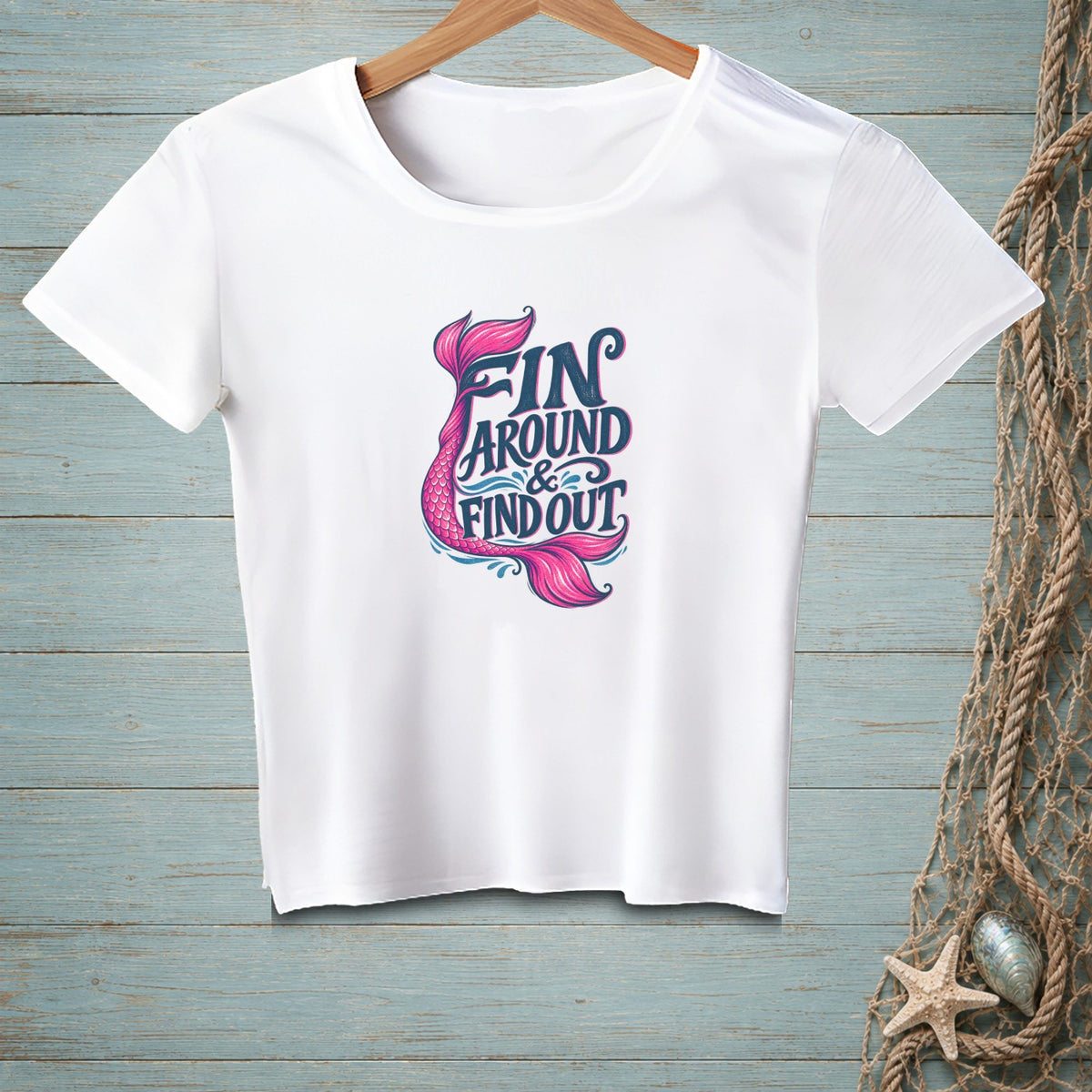 White t-shirt with pink and blue text and mermaid tail graphic.