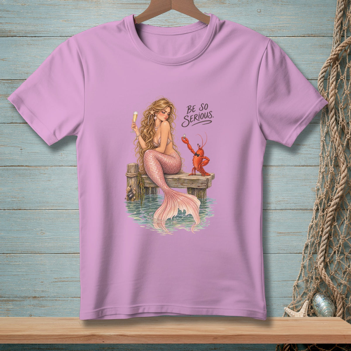 A mermaid with a lobster sits on a dock, with text reading "Be So Serious."