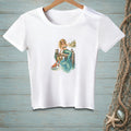 White t-shirt with a graphic of a mermaid sitting on a pier with a crab and beach scene.