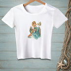 White t-shirt with a graphic of a mermaid sitting on a pier with a crab and beach scene.