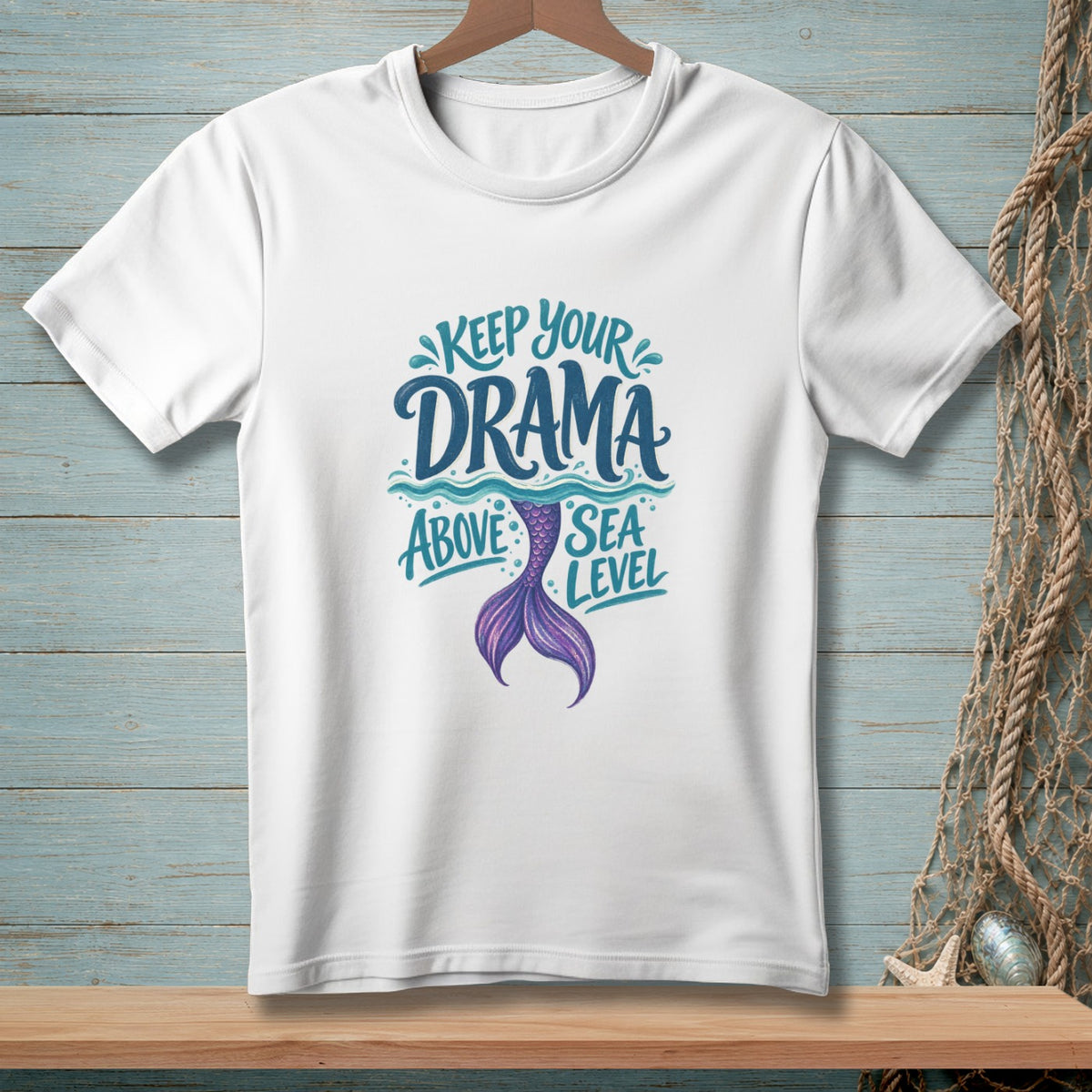 White t-shirt with text "Keep Your Drama Above Sea Level" and mermaid tail.