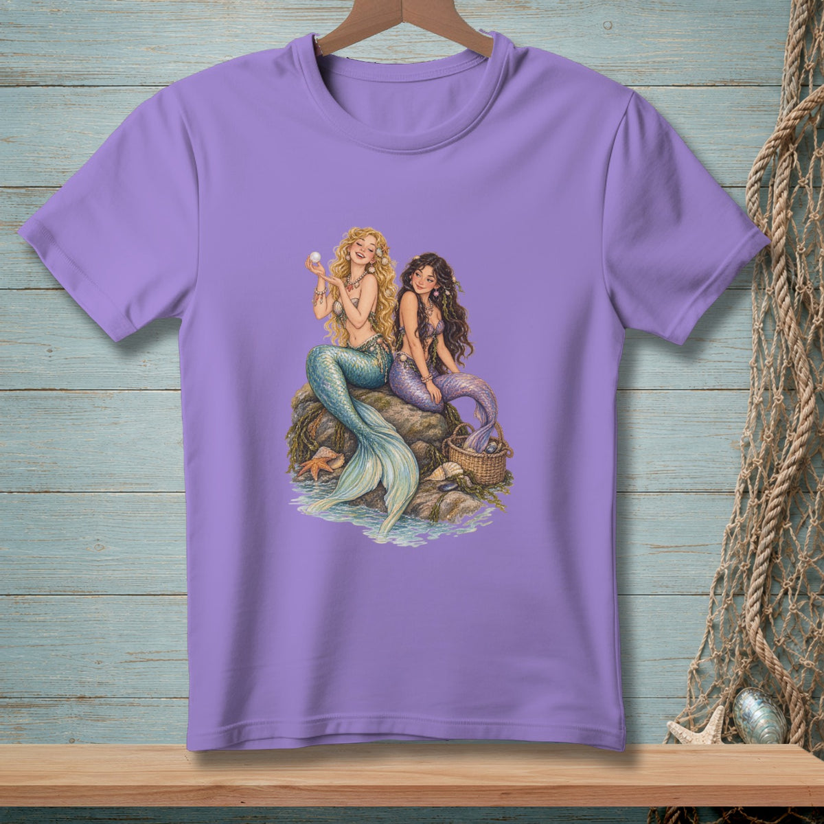 Two mermaids sit on rocks by the water, one holding a pearl.