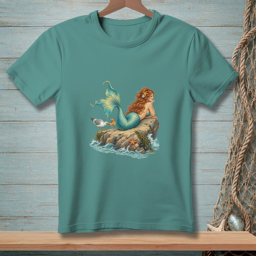 Teal t-shirt featuring a mermaid lounging on a rock with a seagull and cocktails.