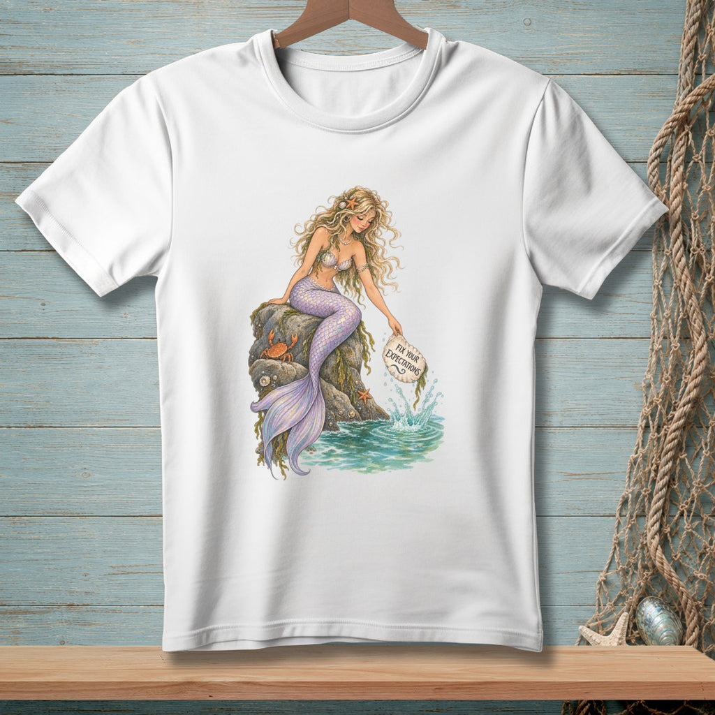 Mermaid sitting on rocks with crabs, holding a sign that says "Fix Your Expectations."